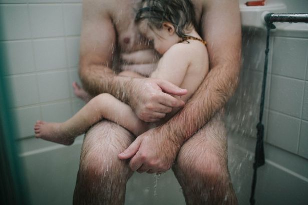 papà che abbraccia il figlio sorro la doccia FOTO